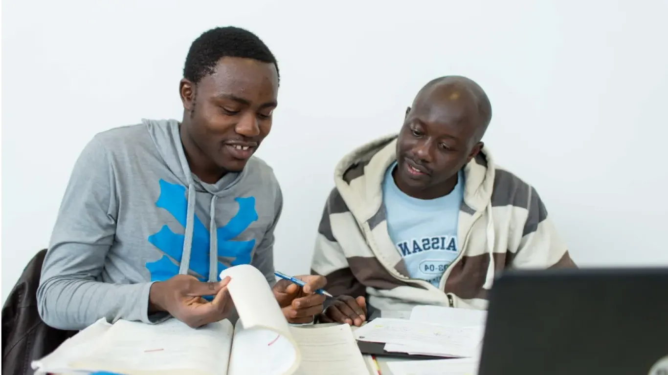 students working together at a table with a laptop