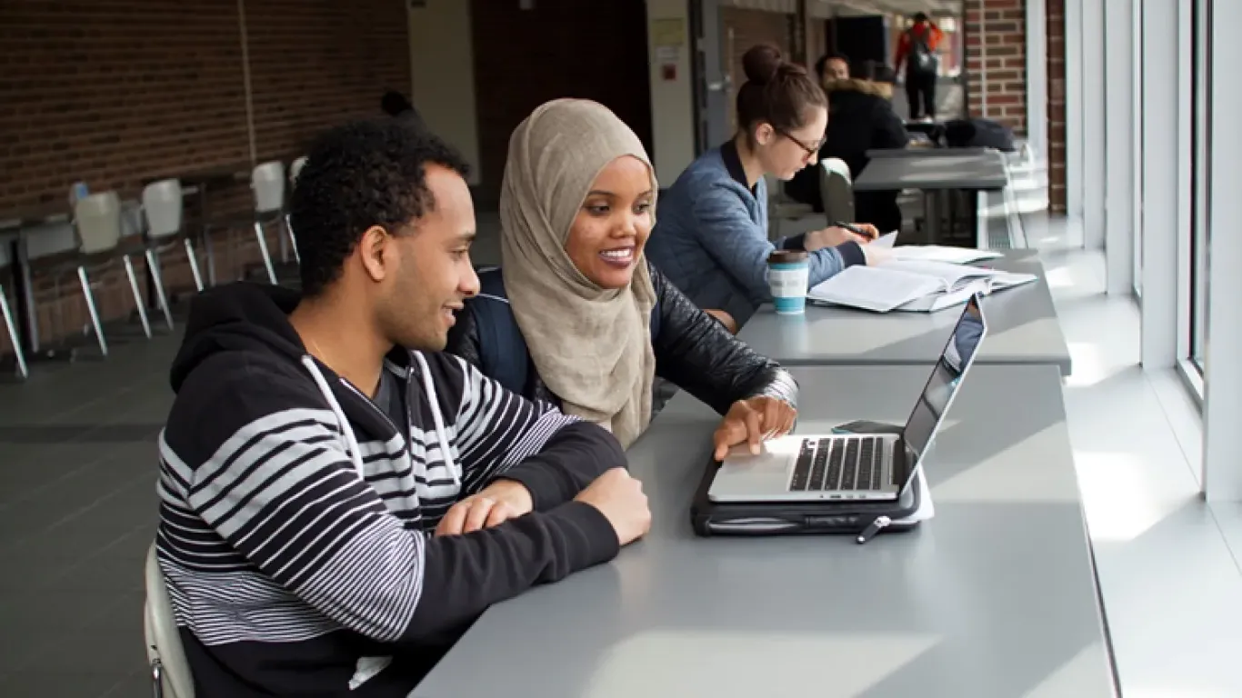 two students looking at a laptop 