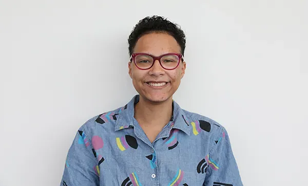 student with glass smiling with a white background